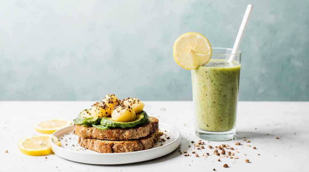 Petit-déjeuner rapide avec toast avocat, smoothie banane et bol de yaourt aux fruits.