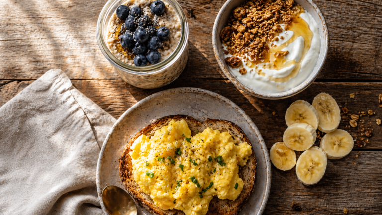 Table de petit-déjeuner avec overnight oats, oeufs brouillés sur toast, yogourt grec et granola